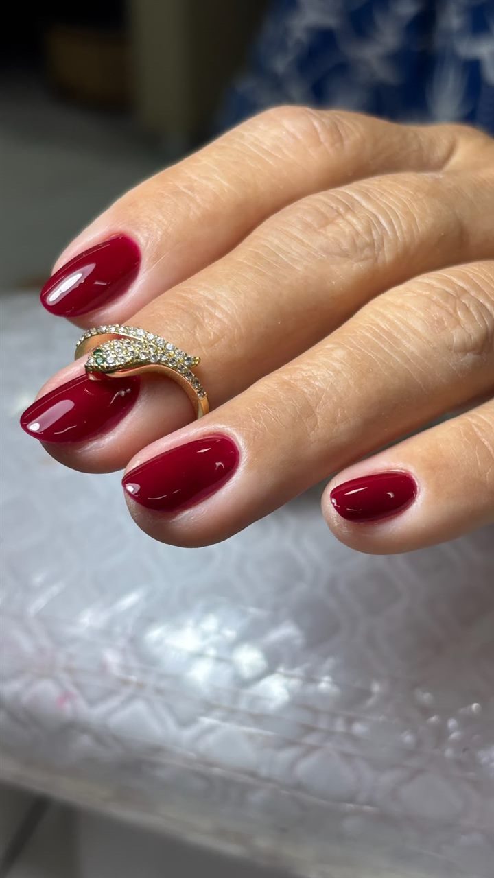 Unhas curtas com esmaltação em gel vinho, acabamento liso e brilhante